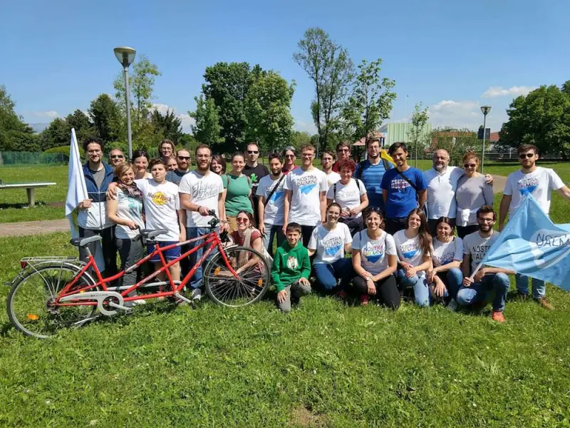 Il gruppo di Nostra Dalmine al completo su un prato durante la campagna elettorale del 2019, con le bandiere, le magliette del gruppo e una bicicletta tandem